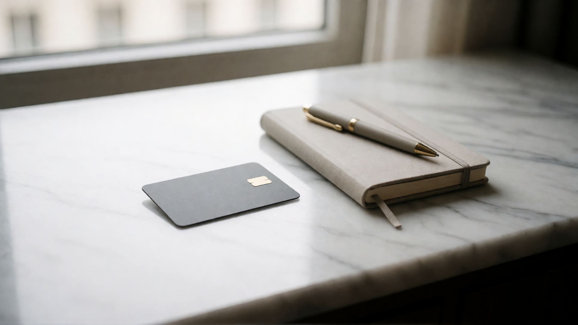 Hotel key card and notebook on a marble surface